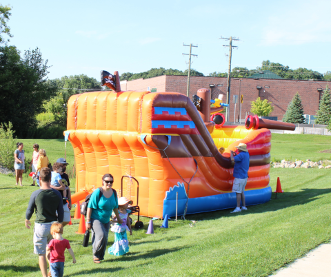 Large inflatable in the shape of a pirate ship with families playing in and around it