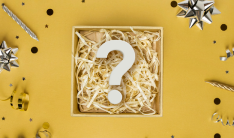 Large question mark inside a box surrounded by party supplies