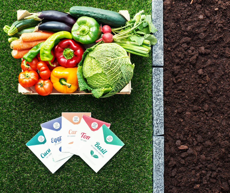 Various seed packets and a crate of vegetables next to a garden.